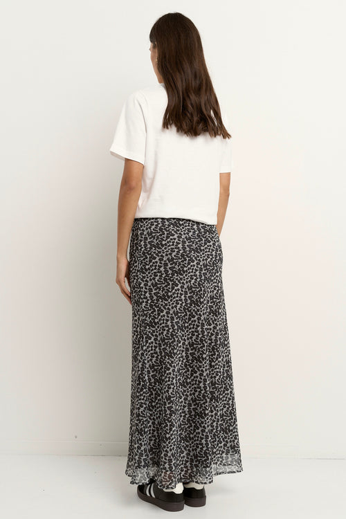 model wears a charcoal leopard bias cut midi skirt with a white t-shirt