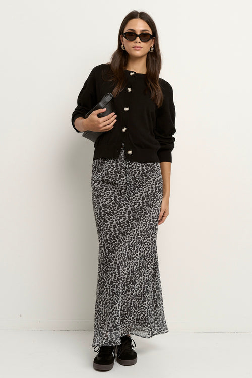 model wears a charcoal leopard bias cut midi skirt with a black cardigan