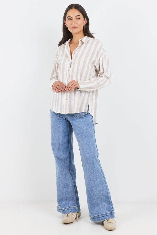 Woman wearing a striped shirt and blue jeans on a white background