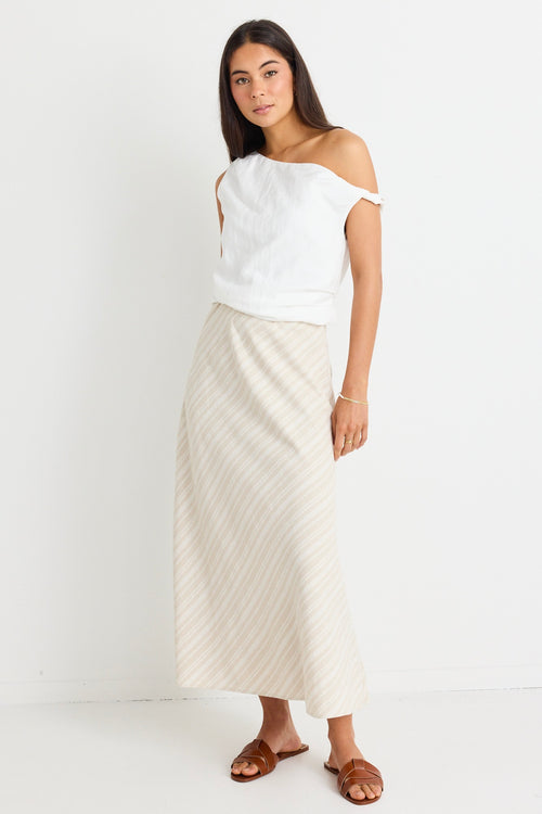 model wears linen one shoulder white top and beige midi skirt