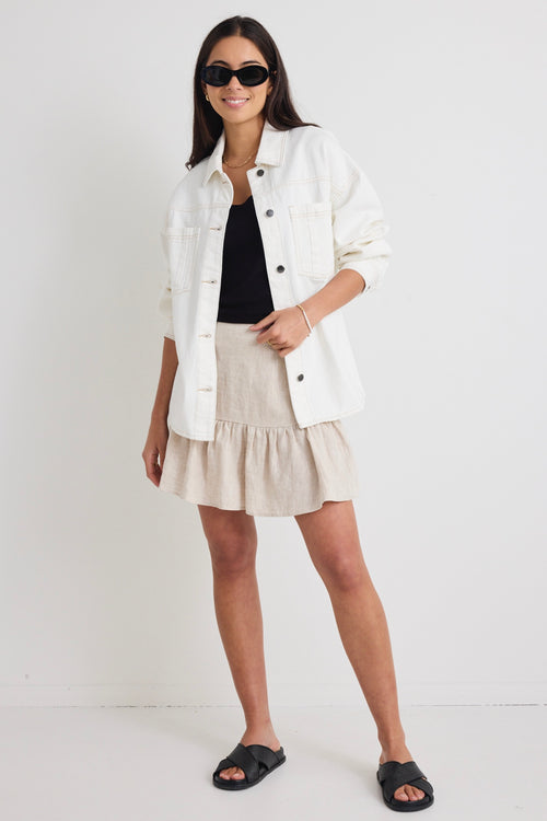 Model wears a ivory white denim jacket with front pockets and button up