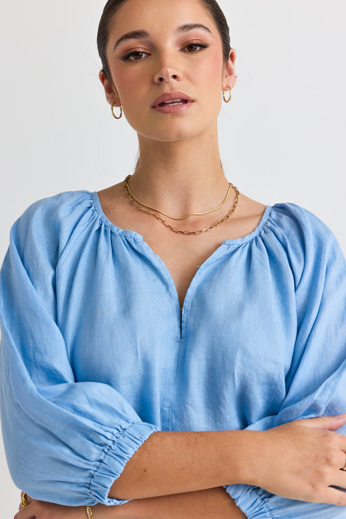 model wears a blue linen blouse