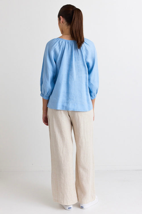 model wears a blue linen blouse