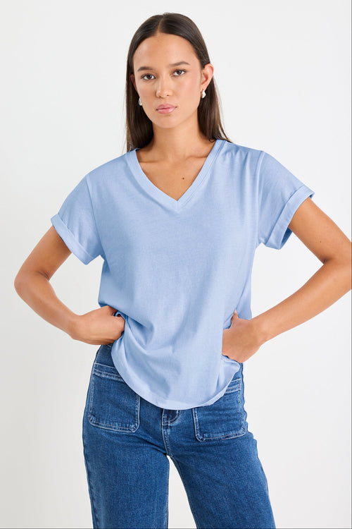 model wearing a blue v neck tee and jeans