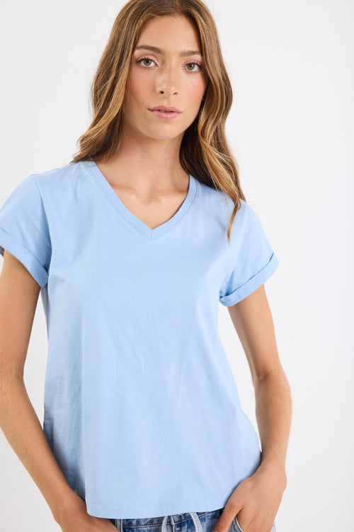 Woman wearing a light blue t-shirt against a white background