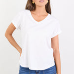 Woman wearing a white t-shirt and blue jeans on a white background