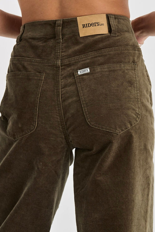 model wears dark olive high ride jean