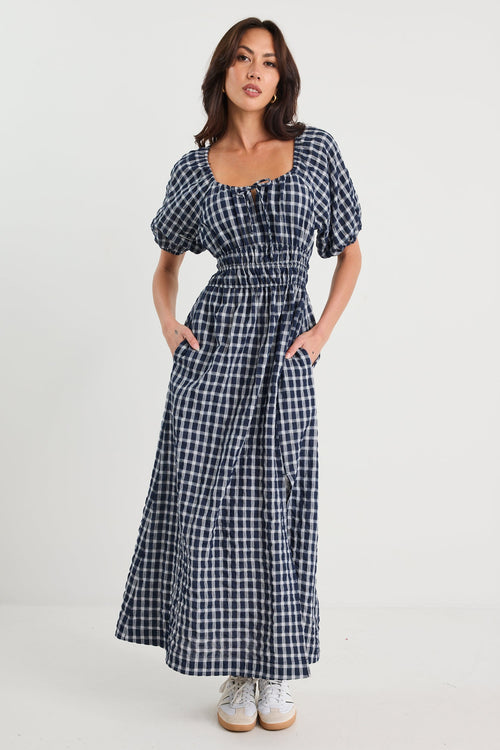 Woman wearing a blue and white checkered dress on a white background