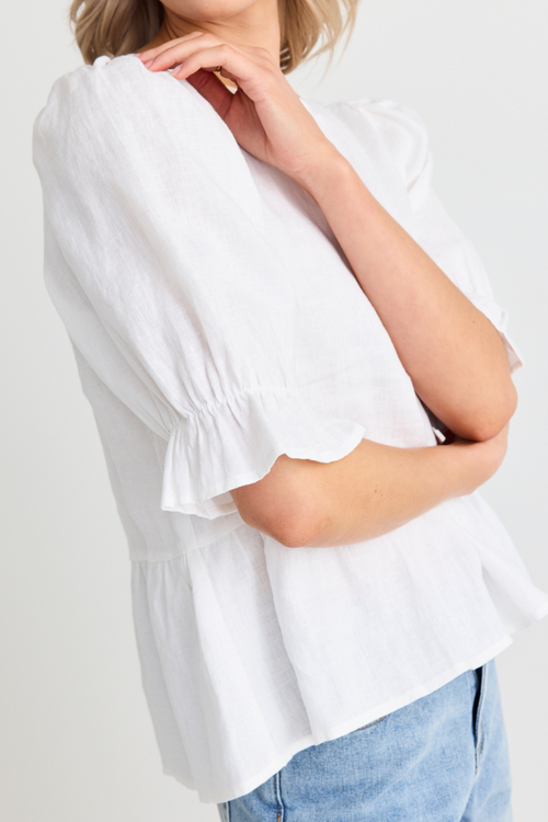 model wears white linen top