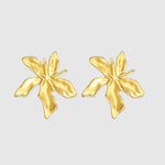 Pair of gold butterfly-shaped earrings on a light gray background