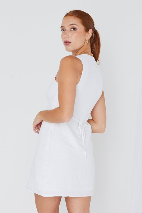 model wears a white linen mini dress