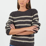 Woman wearing a striped sweater and jeans on a white background