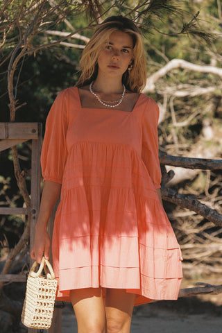 model wears a orange mini dress