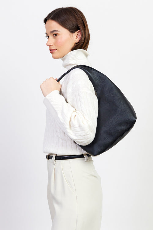Woman wearing a black leather backpack against a white background
