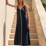 Woman in a navy dress standing on stone steps with a scenic background
