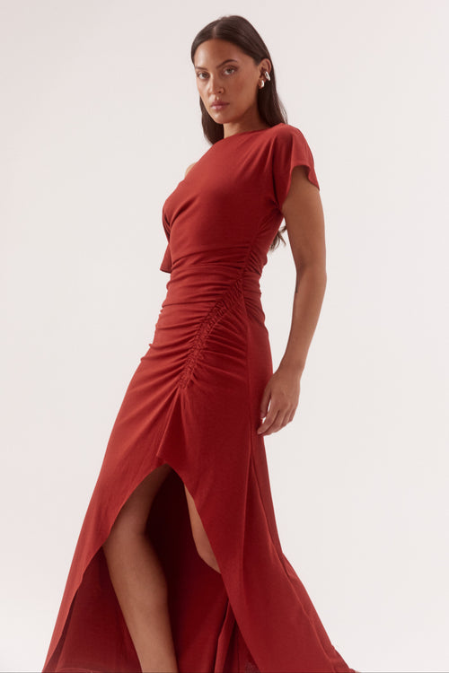 Woman wearing a red dress with a slit on a white background
