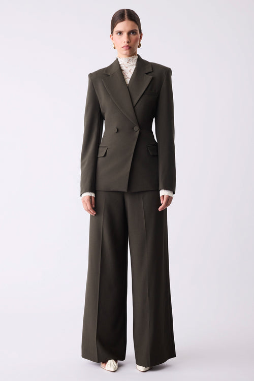Woman wearing a dark green suit on a white background