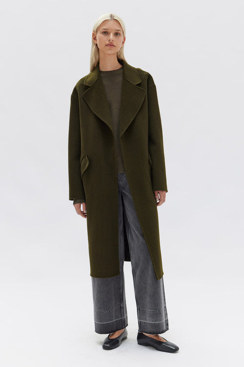 model wears a green wool coat