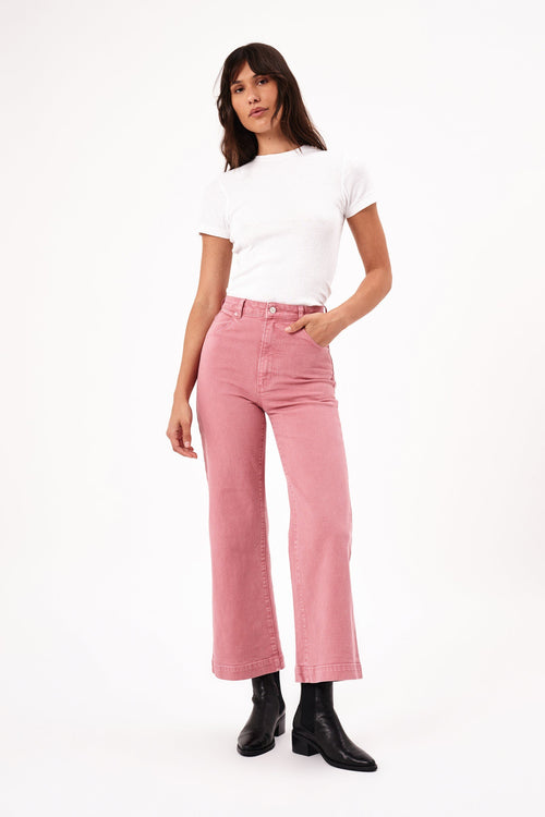 model wears pink jeans with a white tee shirt