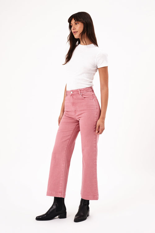 model wears pink jeans with a white tee shirt