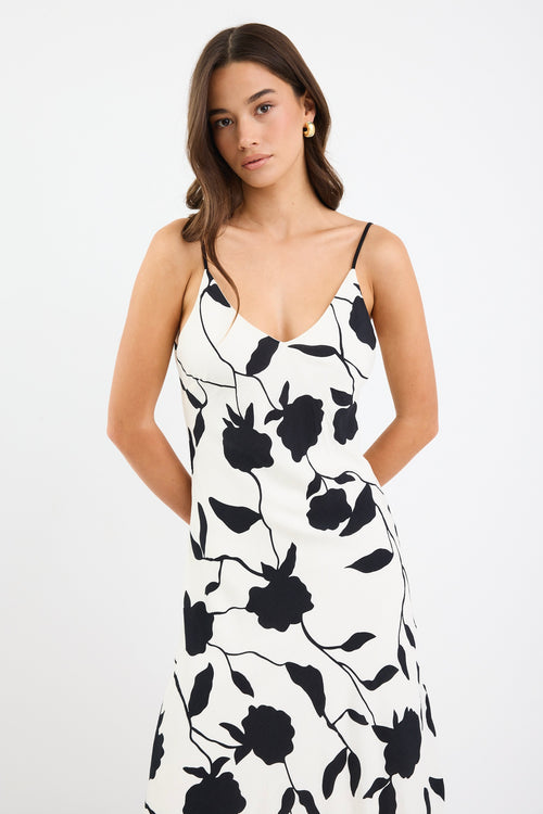 A strappy ivory dress with a bold black floral print, featuring a bias-cut design and fully lined interior. Made from 80% Viscose and 20% Nylon for a soft, breathable feel.