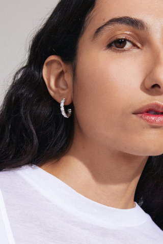 model wearing silver stud hoop earrings