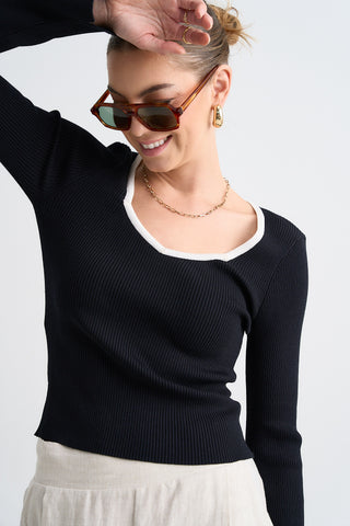 Model wears a black and white ribbed knit top 