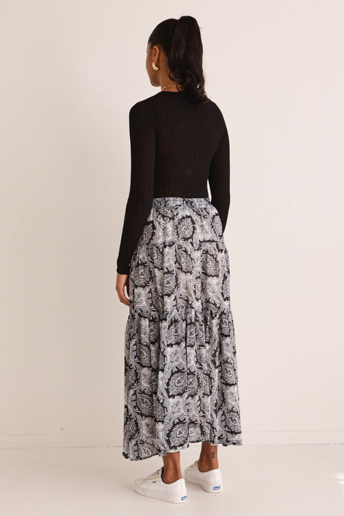 model wears a black print maxi skirt