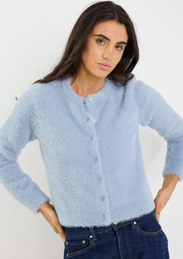 Woman wearing a light blue cardigan against a white background