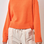 Model wears an orange knit 