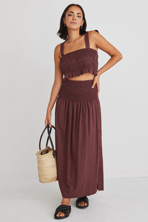 model posing in matching brown crop top and maxi skirt set