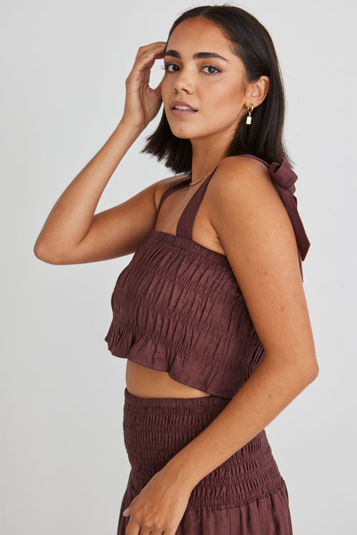 model wearing matching brown crop top and maxi skirt set