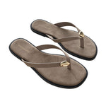 A pair of taupe-brown suede flip-flops with small gold-tone metal accents on the straps and black soles, shown on a plain white background.