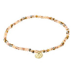 Beaded bracelet with a gold charm on a white background