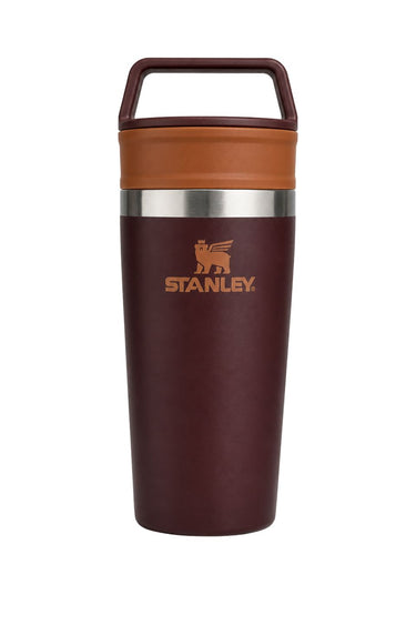 Stanley insulated travel tumbler with a dark burgundy body, a warm brown lid and carrying handle, and a silver stainless steel band around the middle.