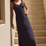 Woman in a black polka dot dress standing on a staircase