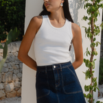model wearing denim skirt and white tank in the sun