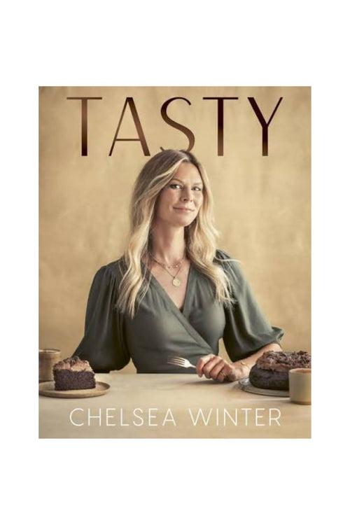 Book cover of 'TASTY' by Chelsea Winter, featuring a portrait of the author seated at a table with cakes and coffee against a warm beige background.