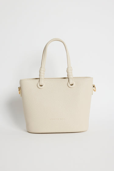 Beige PU leather mini handbag with knotted top handles and a long detachable shoulder strap, photographed against a plain light background.