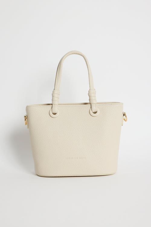 Beige PU leather mini handbag with knotted top handles and a long detachable shoulder strap, photographed against a plain light background.