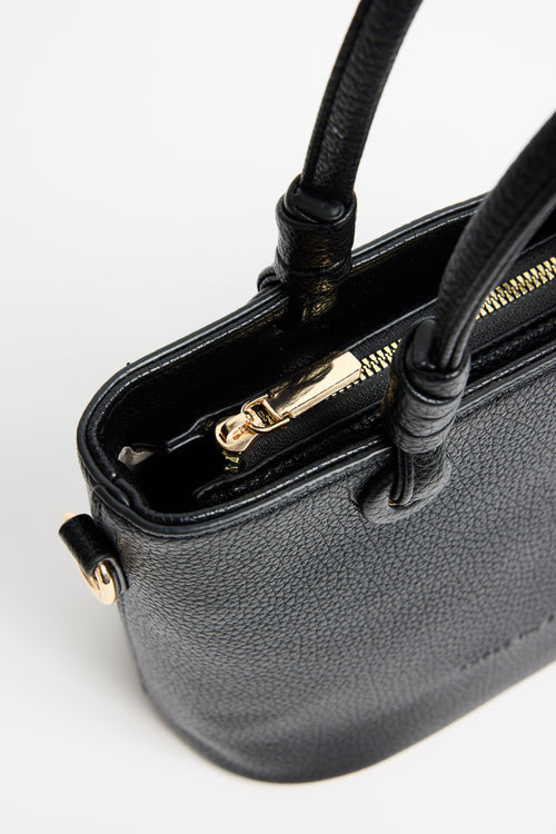 Small black PU leather handbag with knotted top handles and a long detachable shoulder strap, photographed against a plain light background
