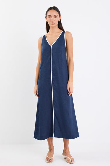 A sleeveless navy dress with ecru contrast piping down the front, featuring side pockets and a relaxed fit. Made from 100% linen for a breathable, comfortable feel.