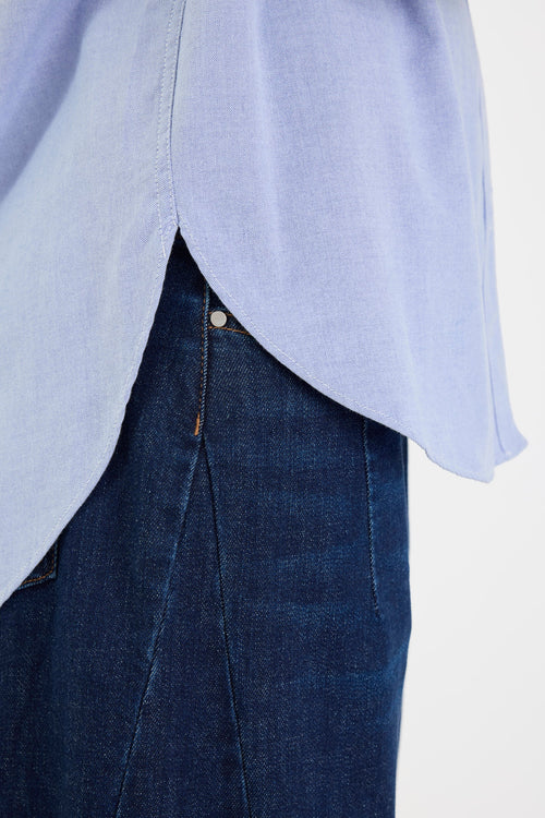 Light blue shirt over dark blue jeans on a white background