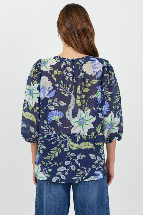 Back of a Woman wearing a floral blouse with a white background