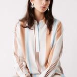 model wears blue, white and brown stripe long sleeve button up shirt