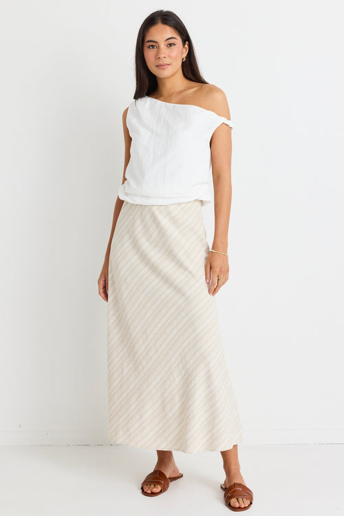 model wears white top and natural linen bias cut midi skirt