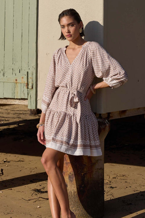 model wears a beige pattern smock mini dress