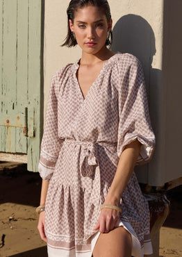 model wears a beige pattern smock mini dress