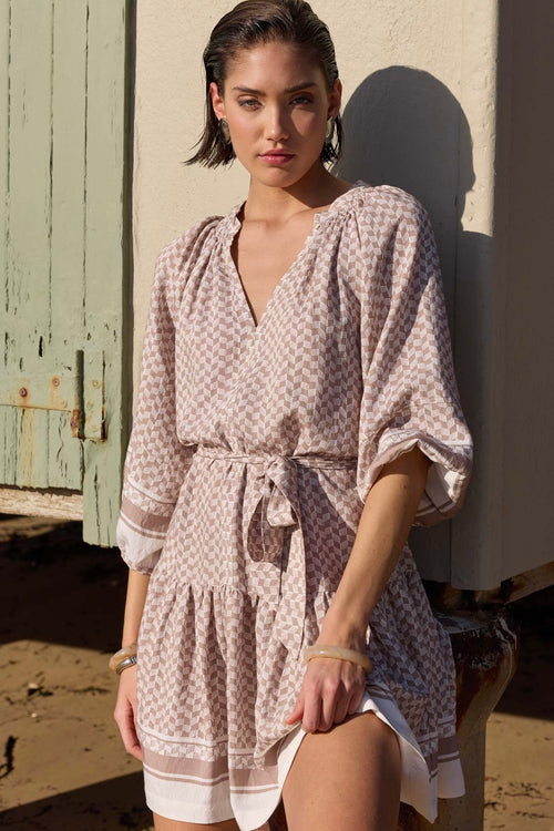 model wears a beige pattern smock mini dress