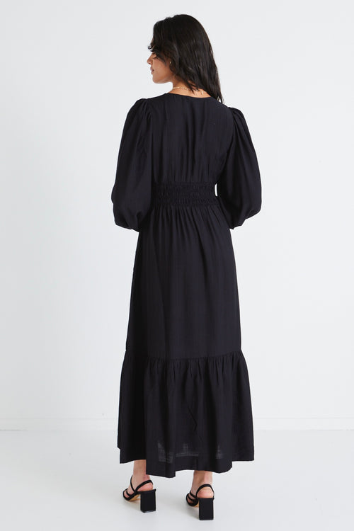 model wears a black maxi dress